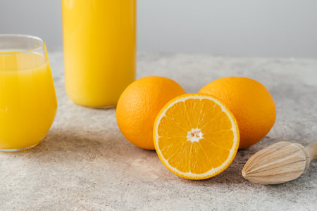 Jar and glass of orange juice, orange fruit and squeezer on white background. Half of ripe orange. Freshly made drink with vitaminsの写真素材