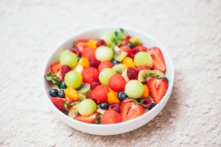 Healthy fruit spring salad. Healthy diet concept. Delicious fresh berries in bowl. Selective focus. Top view. Colourful fruits mixed in homemade salad. Nutrition conceptの写真素材