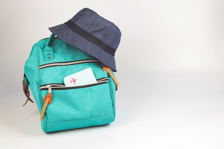 Front view of green backpack with passport cover and bucket hat  on white background with copy space.. Travel accessories concept.の写真素材