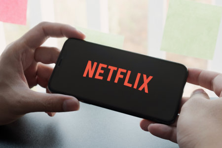 CHIANG MAI, THAILAND, MAR 25 , 2020: Woman hand holding Smart Phone with Netflix logo on Apple iPhone Xs. Netflix is a global provider of streaming movies and TV series.のeditorial素材