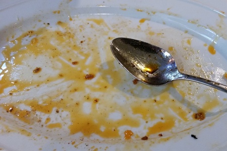 An empty white plate and a spoonの写真素材