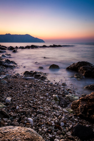long exposure at Sunset on a beach stones - Conero, Italyの写真素材