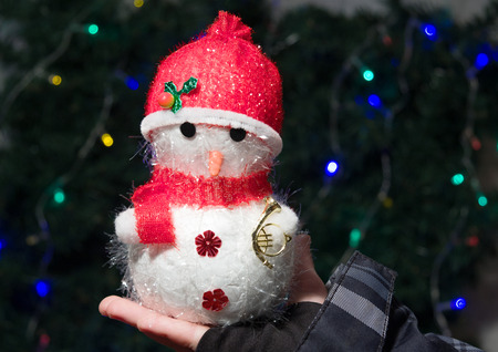 snowman in red hat in children's handsの写真素材