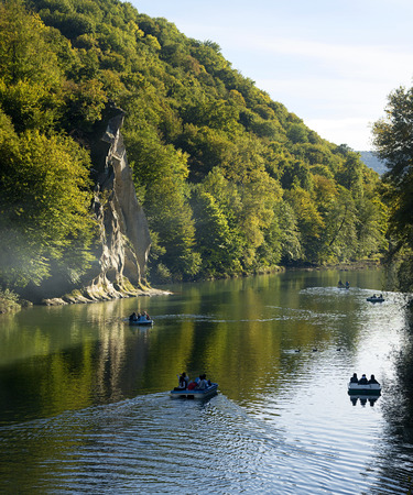 relaxing on a boat floating on a mountain river close to the rock in the forestの写真素材