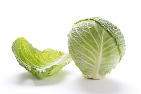 whole raw green cabbage isolated on a white surface with a single leaf removedの写真素材