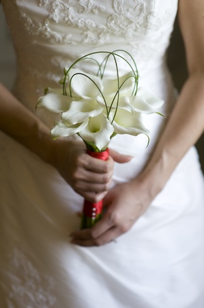 bride holding a wedding bouquet of fresh lilies の写真素材