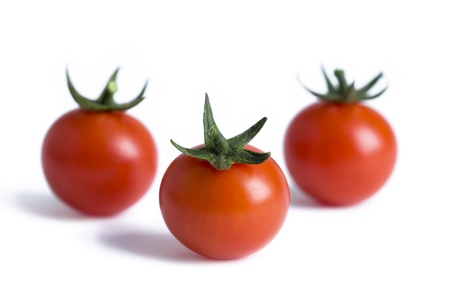 three ripe cherry tomatoes isolated on a white backgroundの写真素材