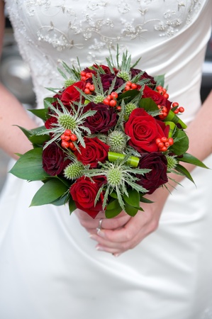 bride holding a bouquet of roses at her wedding の写真素材