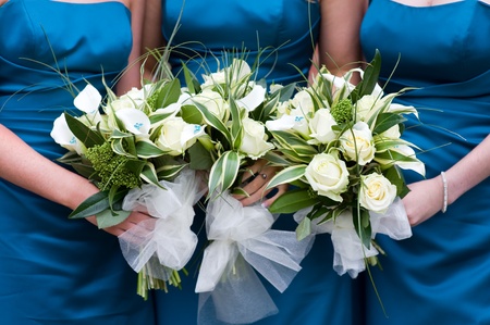bridesmaids holding bouquet of flowers at a weddingの写真素材