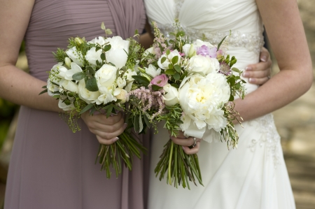 bride and bridesmaid holding floral wedding bouquets の写真素材