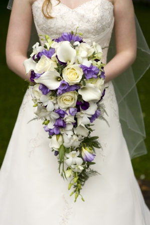 bride holding a large teardrop wedding bouquetの写真素材