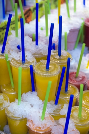 stacked smoothies and juice drinks  on display with iceの写真素材