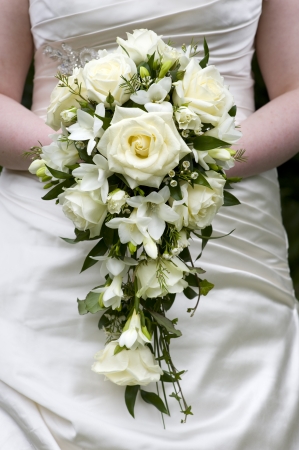 bride holding a wedding bouquet of white rosesの写真素材