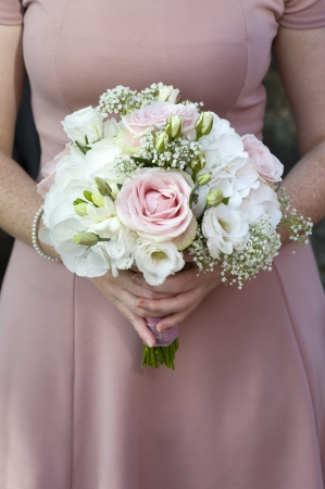 single bridesmaid hold a bouquet of pink and white rosesの写真素材