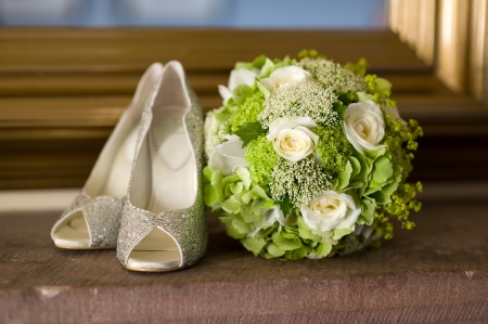 wedding shoes and wedding bouquet of white rosesの写真素材