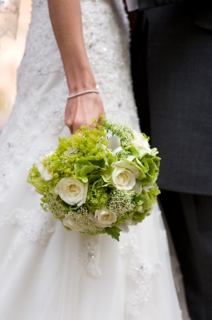bride holding a wedding bouquet of white rosesの写真素材