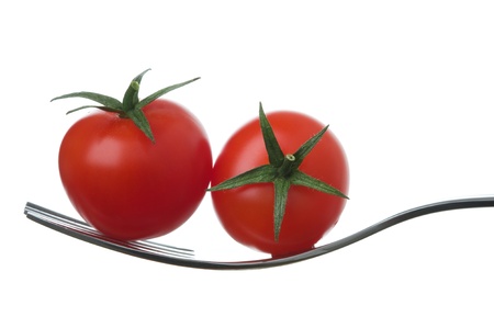 two ripe cherry tomatoes on a fork against whiteの写真素材