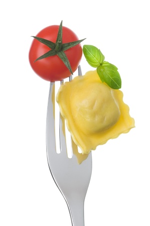 ravioli pasta tomato and basil on a fork against white backgroundの写真素材