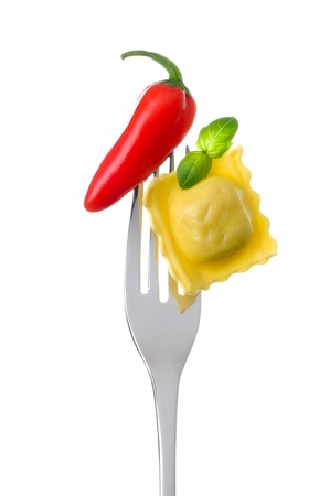 red hot chili pepper ravioli pasta and basil on a fork against whiteの写真素材