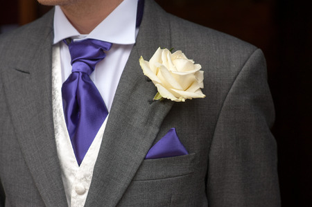 man wearing a rose buttonhole wedding flowersの写真素材