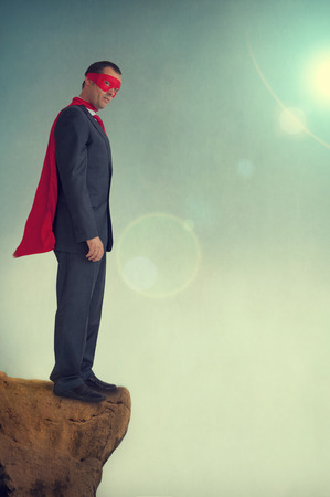 superhero businessman standing on a precipice の写真素材