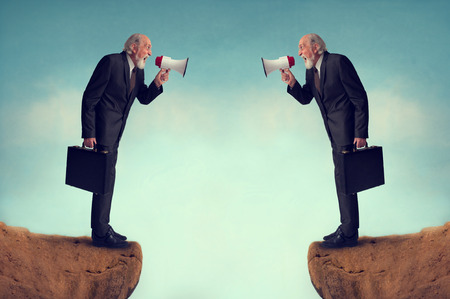 businessmen shouting through megaphones business conflict conceptの写真素材