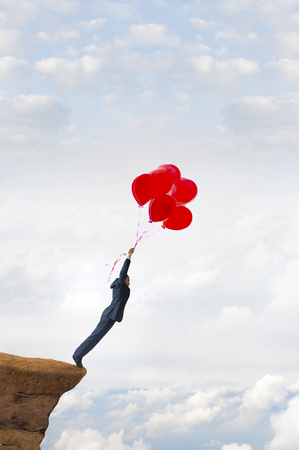 business risk concept courageous daring businessman holding balloonsの写真素材