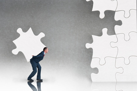 business puzzle concept businessman working to complete a jigsawの写真素材
