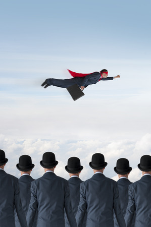 business progress concept superhero businessman flying past static competitionの写真素材
