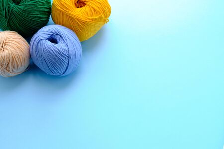Mock-up made with right color yarn clews on the blue background. Concept of amigurumi toy making,...
