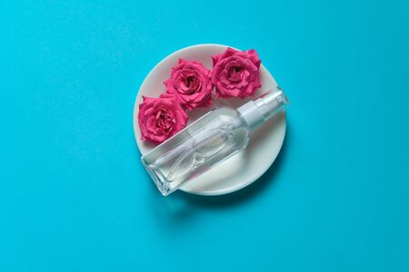 Roses spray antiseptic fragrance with blank space for text insertion, blue background for natural gmo free cosmeticsの写真素材