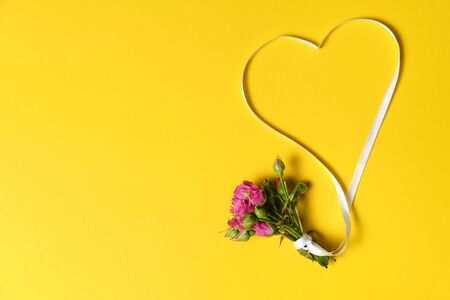 bouqet on yellow background with white ribbon, offer of marriage, beautifulの写真素材