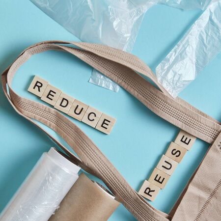 Brown empty Tote Bag next to eco unfriendly pouches and wrap, reducing consumer excess wraps, reusability conceptの写真素材