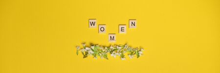 Top view women spelled in wooden blocks on yellow background. Love, 8 march background. Gift,...