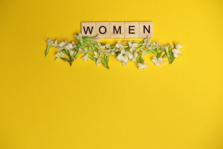 Top view woman spelled in wooden blocks on blue background. Love, 8 march background. Gift, greeting, compliment concept. Copy space. place for textの写真素材