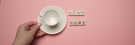 stayhome with woman hand holding coffee cup on bright pink backgroundの写真素材