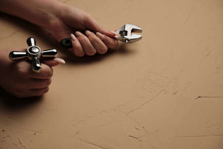 Girl holding a wrench. Tool for plumbing repair with their hands Wrench close-up in a woman hand.