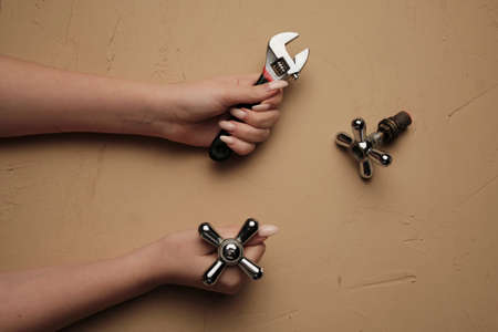 Girl with a wrench. Tool for plumbing repair with their hands Wrench close-up in a woman hand.の写真素材