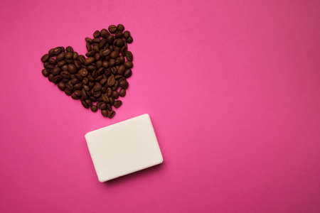 Handmade coffee scented soap on bright background with coffee beans in shape of heartの写真素材