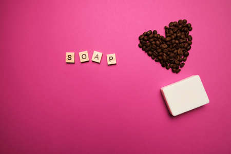 Handmade coffee scented soap on bright background with coffee beans in shape of heartの写真素材