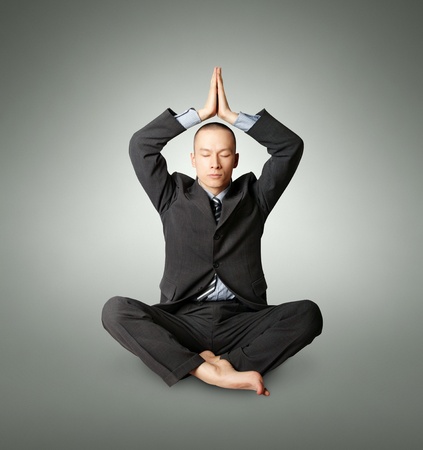 businessman in yoga pose meditating at the officeの写真素材