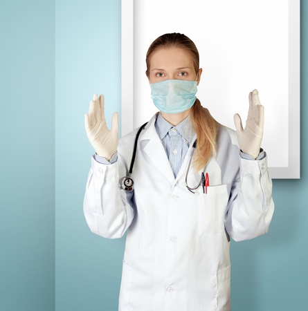 doctor woman in mask looking at camera isolated on different backgroundsの写真素材