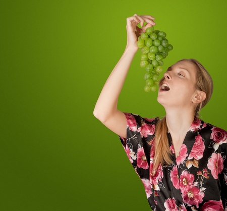 cute woman with green branch of grapesの写真素材