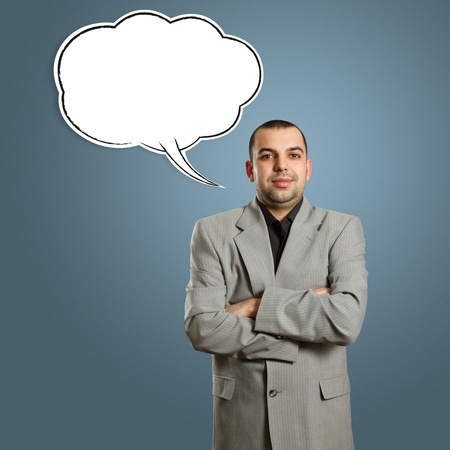 male in suit with crossed hands and speech bubble, looking on camera