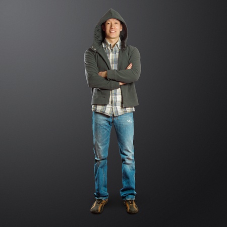 asian male standing up straight with folded handsの写真素材