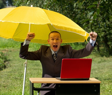 businessman with umbrella, hiding from the sunの写真素材