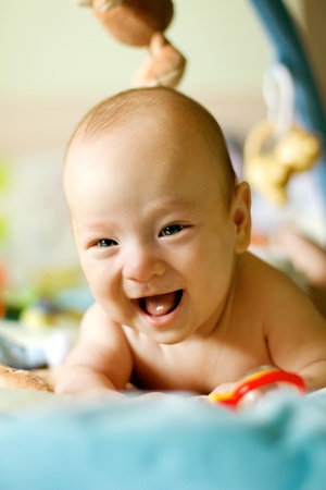 Baby lying on his bed, laughingの写真素材