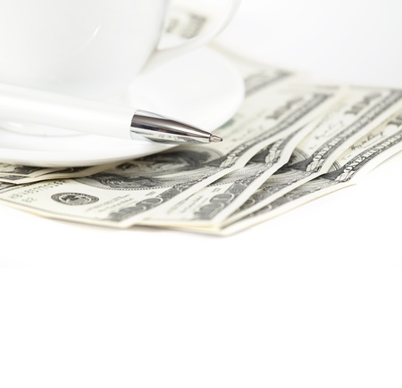 Dollars background with cup of coffee ant pen, against white backgroundの写真素材