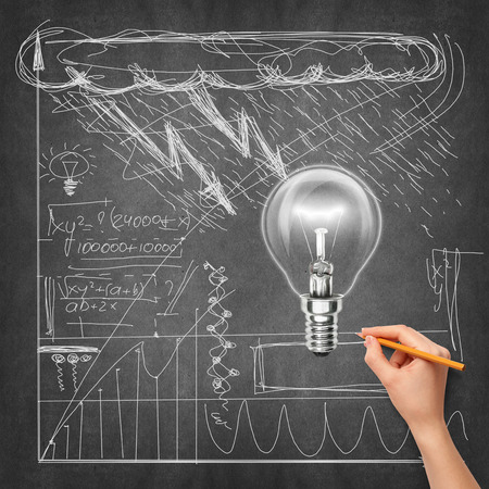 Idea background with lamp, sketch and human hand with pencilの写真素材