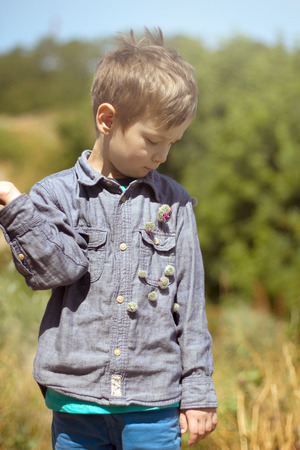 Happy child playing outdoors. Boy looking at camera and smilingの写真素材